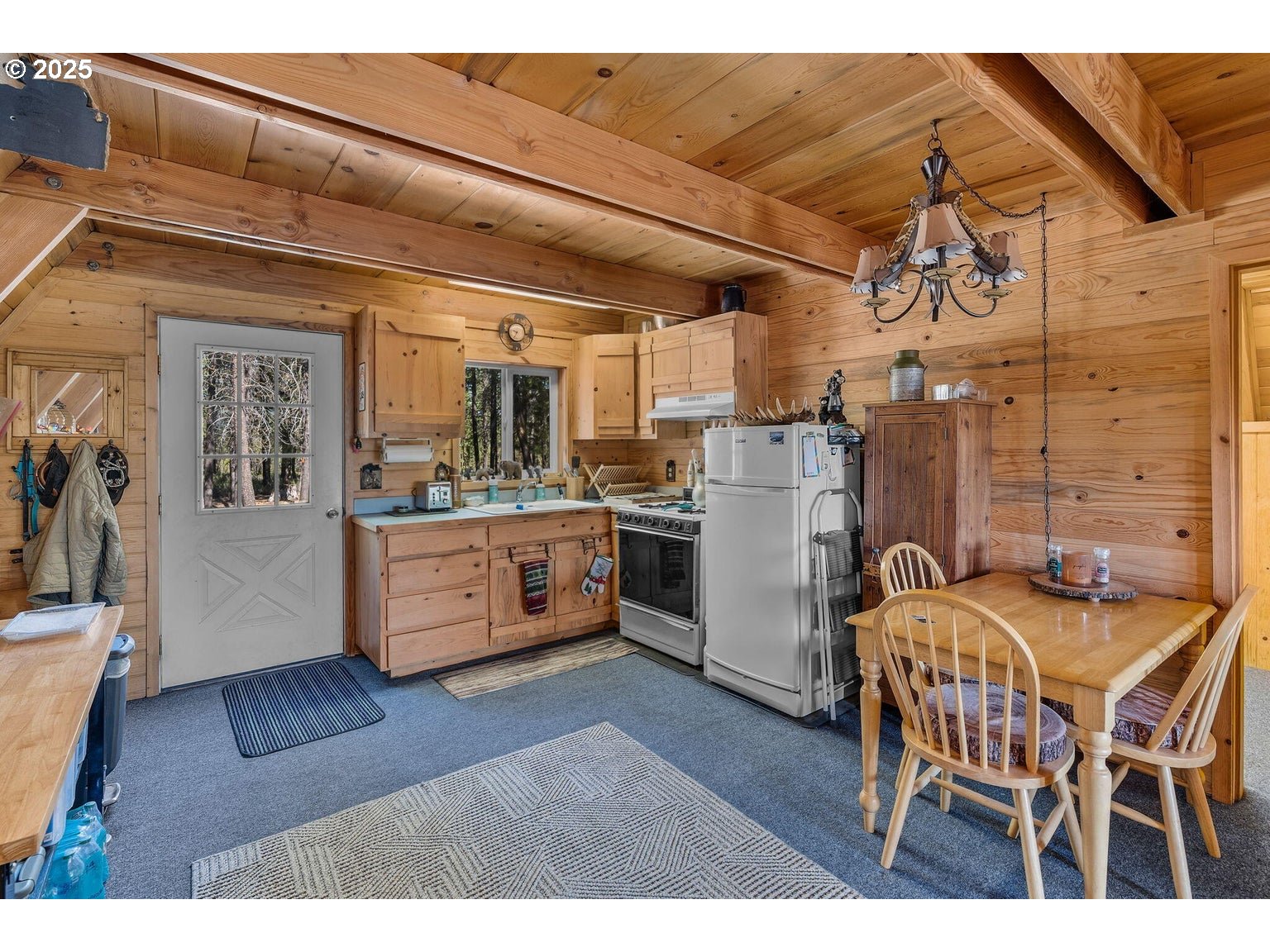 143970 Highway 97 Gilchrist, OR 97737 - Photo 10 of 30 a kitchen with a table chairs refrigerator and cabinets