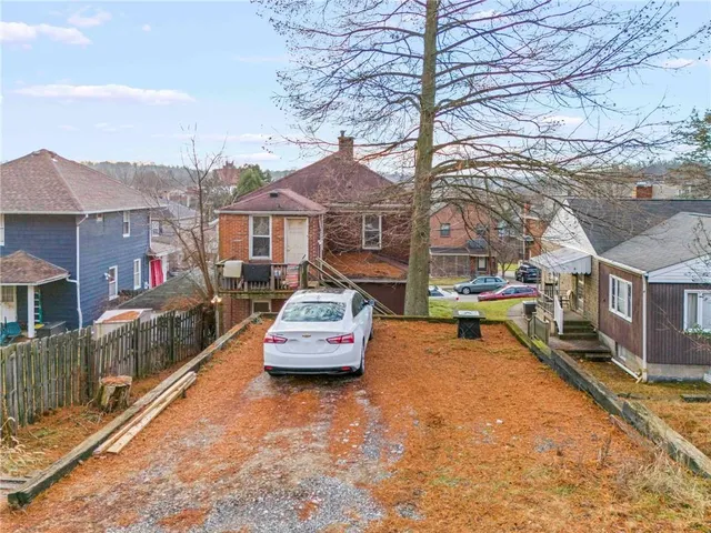 a front view of a house with a yard and large trees