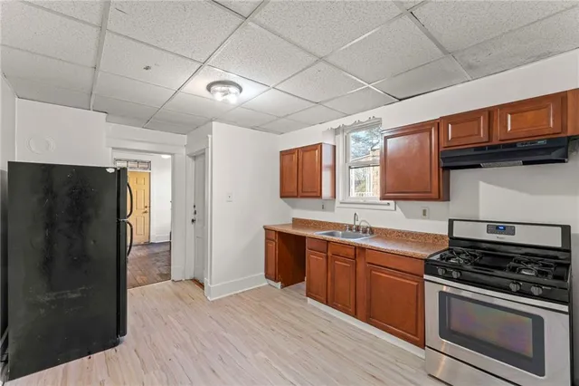 a kitchen with stainless steel appliances granite countertop a stove a refrigerator and a sink