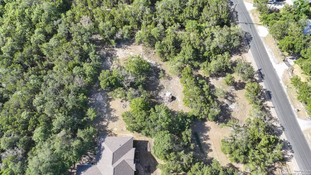 an aerial view of residential house with outdoor space and trees all around