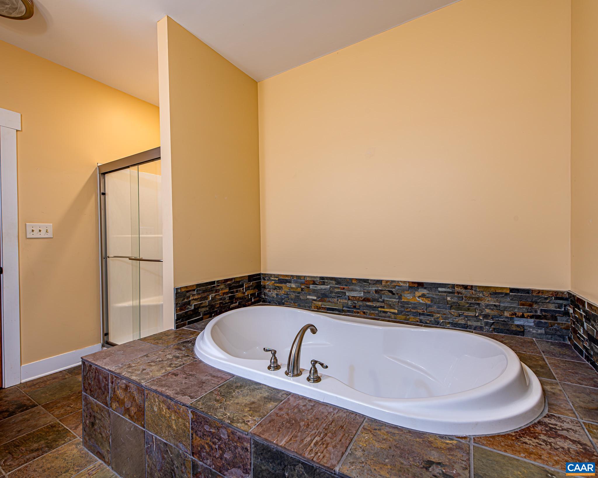 1671 Dudley Mountain Road Charlottesville, VA 22903 - Photo 22 of 60 a bathroom with a bathtub and mirror