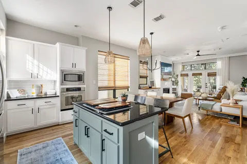 a kitchen with stainless steel appliances granite countertop a stove oven and a view of living room