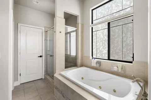 a bathroom with a tub a sink and a window