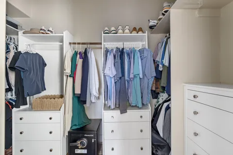 a view of walk in closet with clothes and shoes