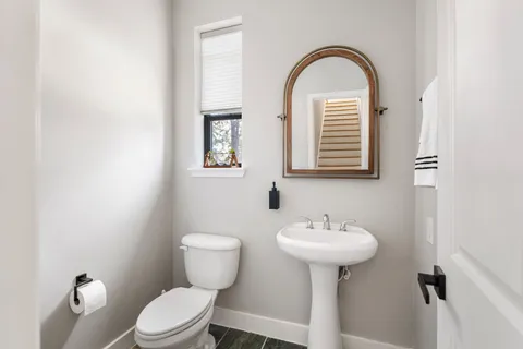 a bathroom with a toilet sink and mirror
