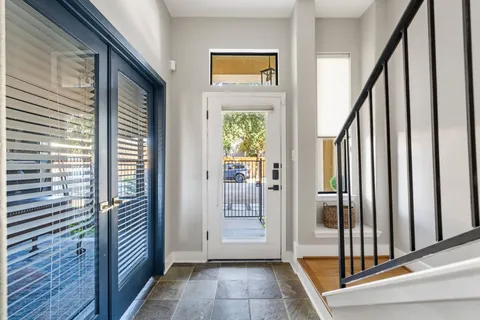 a view of a hallway with wooden floor and windows