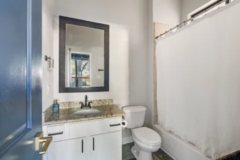 a bathroom with a granite countertop sink toilet and shower