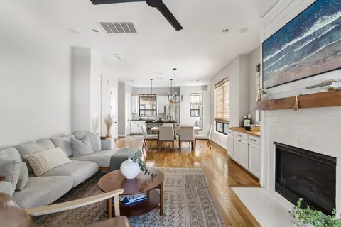 a living room with furniture large window and a fireplace