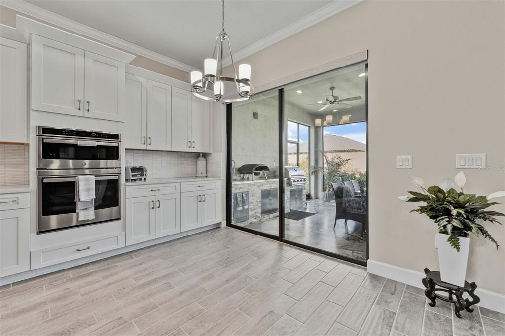 4951 Freccia Loop Wesley Chapel, FL 33543 - Photo 12 of 43 a view of a kitchen with stainless steel appliances granite countertop a stove a sink dishwasher a refrigerator and microwave with wooden floor
