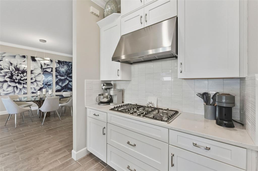 4951 Freccia Loop Wesley Chapel, FL 33543 - Photo 16 of 43 a kitchen with white cabinets and a stove top oven