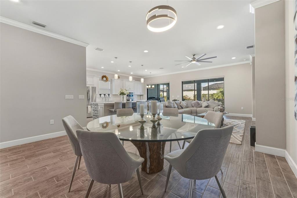4951 Freccia Loop Wesley Chapel, FL 33543 - Photo 17 of 43 a view of a dining room with furniture and wooden floor