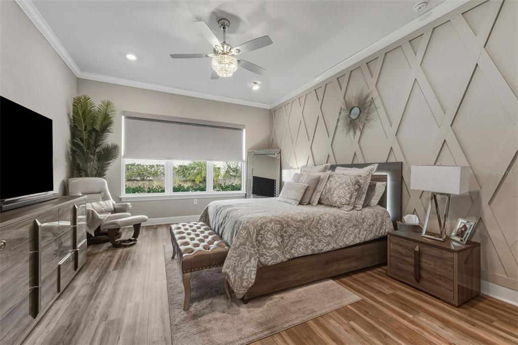 4951 Freccia Loop Wesley Chapel, FL 33543 - Photo 20 of 43 a spacious bedroom with a large bed and a flat tv screen on dresser