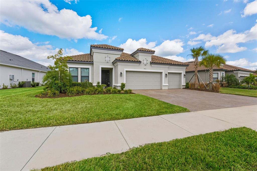 4951 Freccia Loop Wesley Chapel, FL 33543 - Photo 2 of 43 a view of a white house next to a yard and large trees