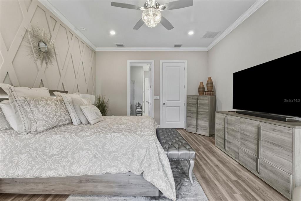 4951 Freccia Loop Wesley Chapel, FL 33543 - Photo 21 of 43 a spacious bedroom with a bed and a flat screen tv