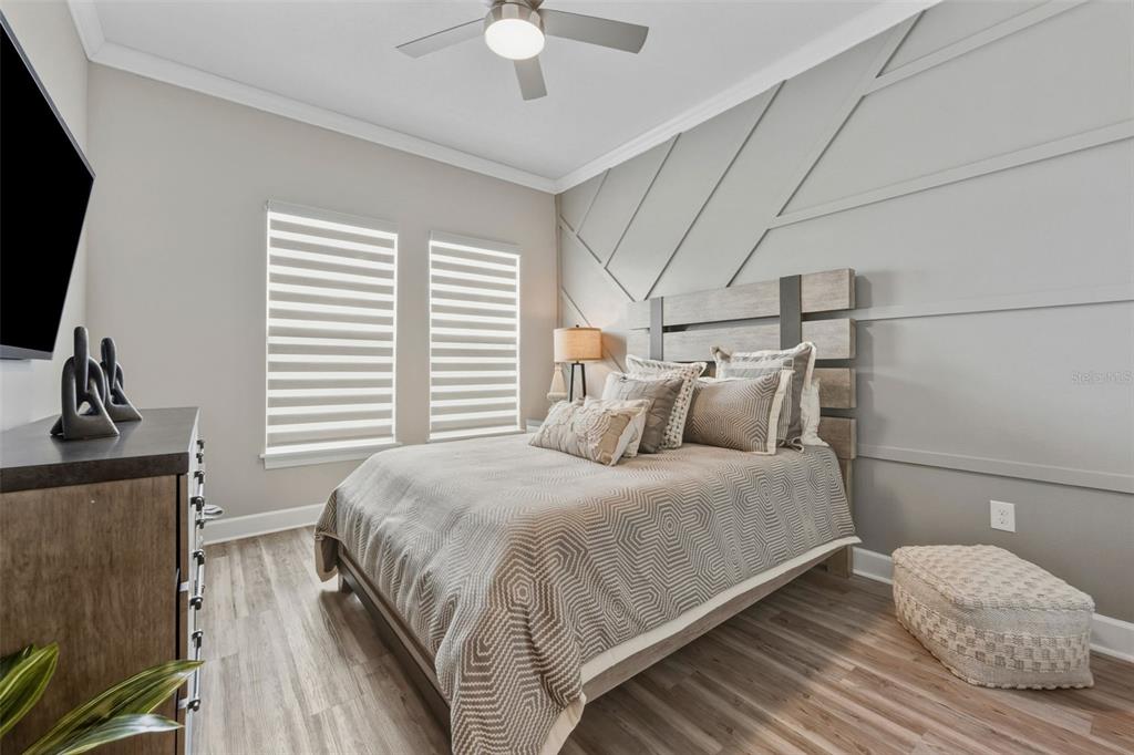 4951 Freccia Loop Wesley Chapel, FL 33543 - Photo 25 of 43 a bedroom with a bed and a flat screen tv