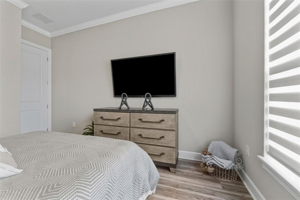 4951 Freccia Loop Wesley Chapel, FL 33543 - Photo 26 of 43 a bedroom with a bed and a flat screen tv