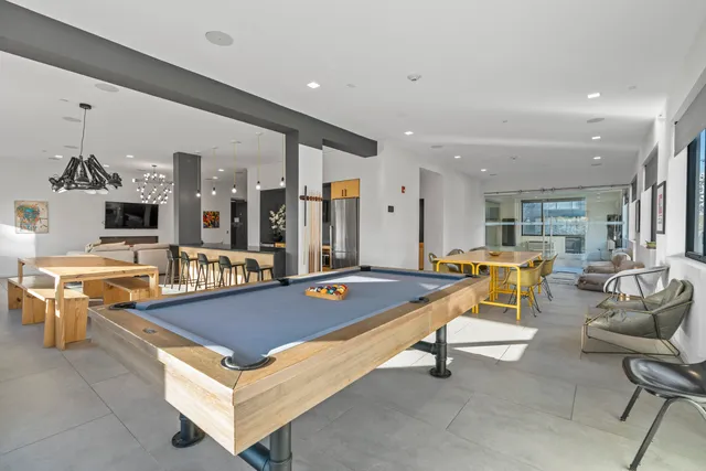 a living room with furniture pool table and flat screen tv