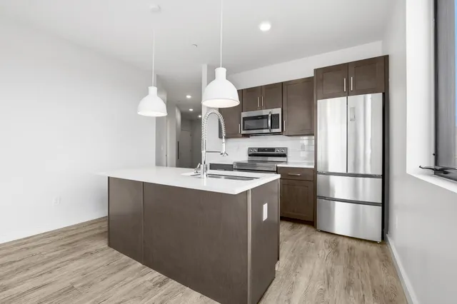 a kitchen with kitchen island a sink stainless steel appliances and cabinets