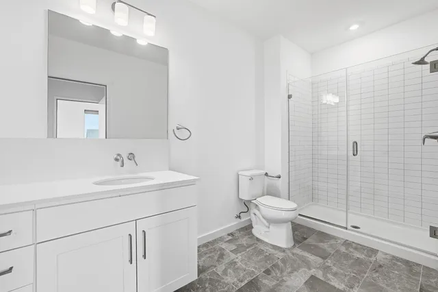 a bathroom with a sink a toilet and shower