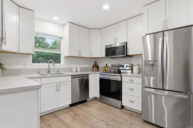 a kitchen with stainless steel appliances granite countertop a refrigerator sink and stove