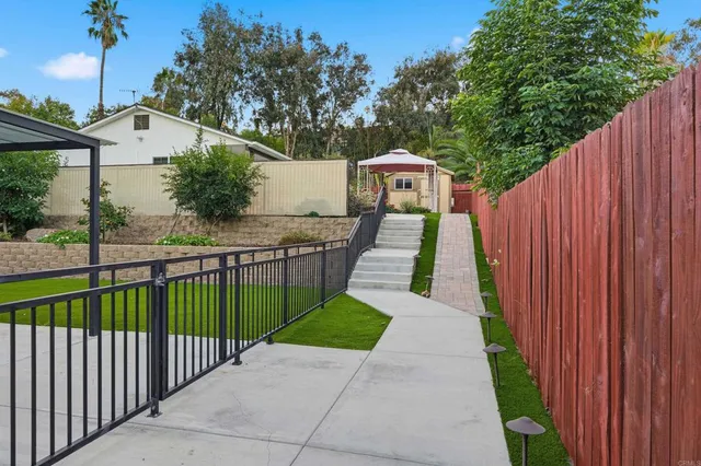 a view of a pathway with a wrought fence