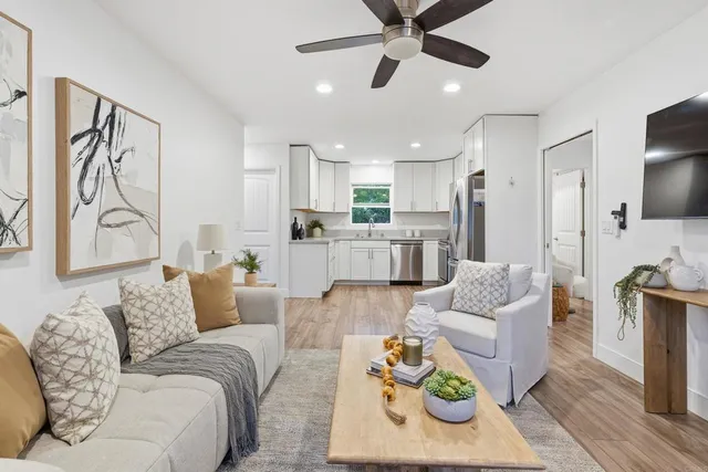 a living room with furniture and a view of kitchen