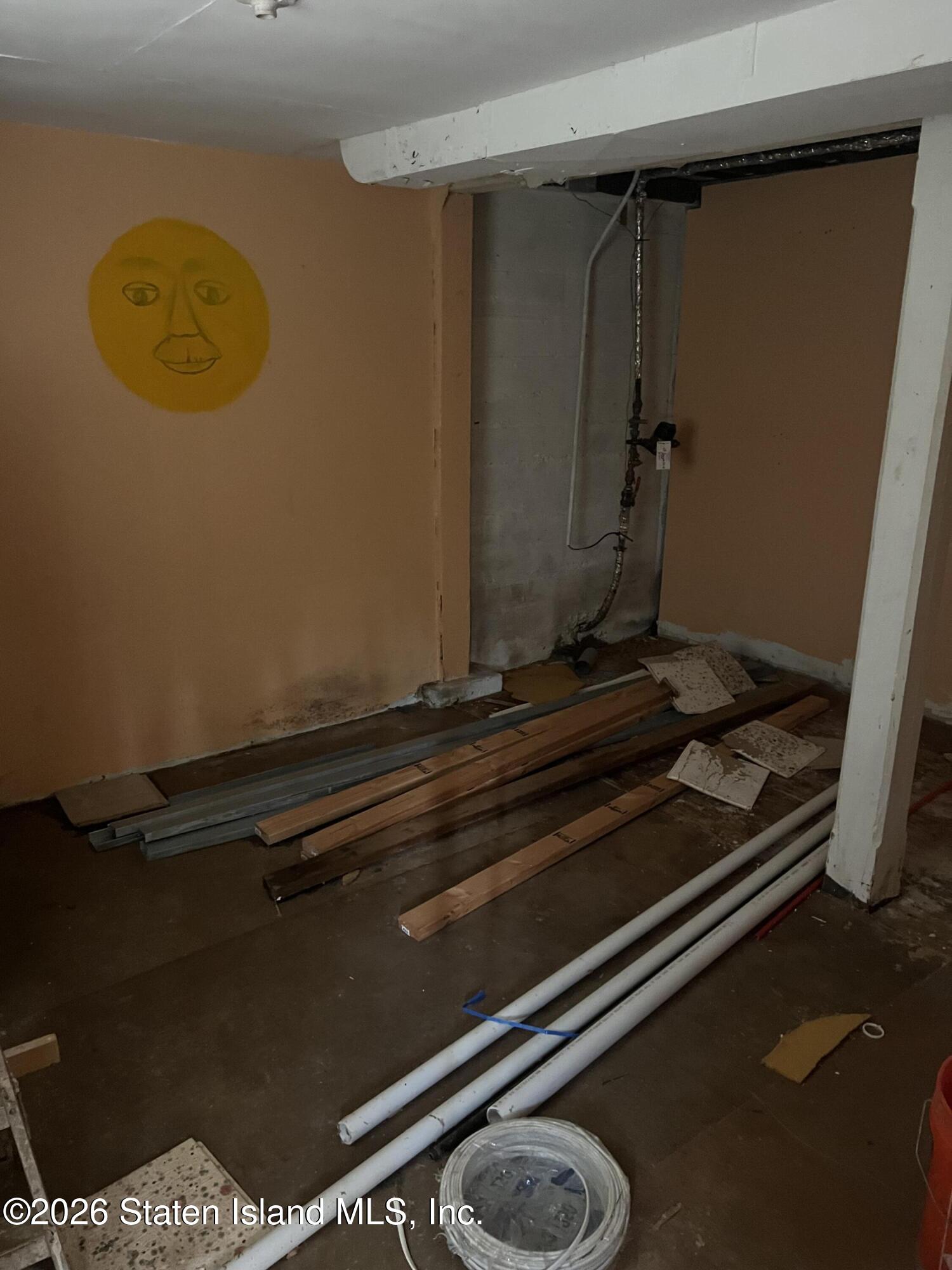 634 Drumgoole Road East Staten Island, NY 10312 - Photo 10 of 10 a room with water heater and a wooden floor