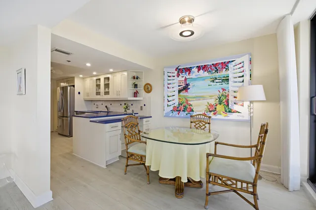 a kitchen with a dining table chairs and refrigerator