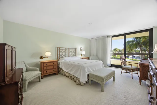 a spacious bedroom with a bed and large windows