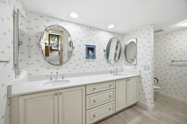 a bathroom with a double vanity sink mirror and shower