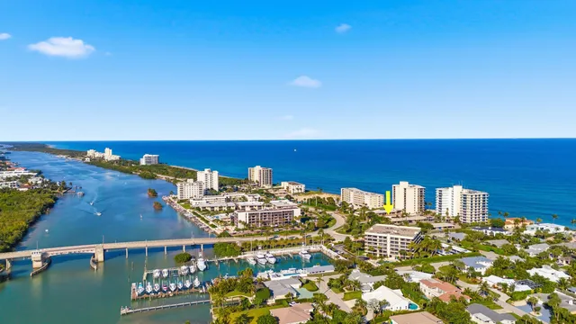 an aerial view of ocean and residential houses with outdoor space