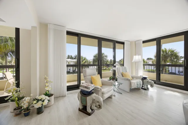 a living room with furniture and floor to ceiling windows