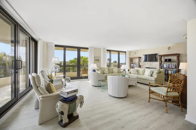 a living room with furniture and large windows