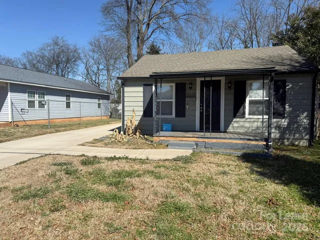 a front view of a house with a yard outdoor seating and garage