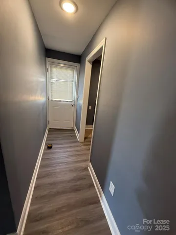 a view of a hallway with wooden floor and staircase