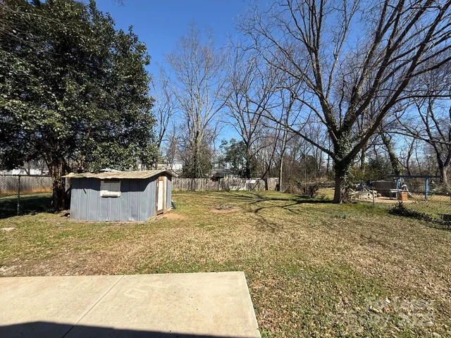 a view of a yard with wooden fence