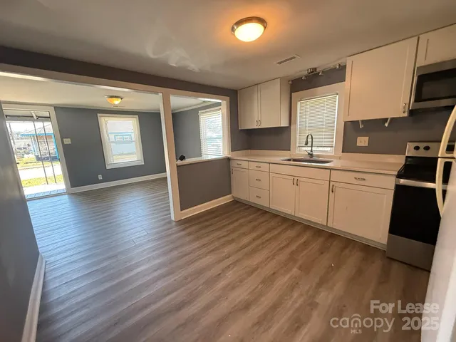 a kitchen with wooden floors and white appliances