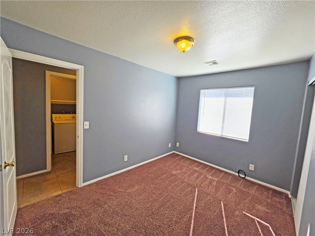 1444 Star Road, Unit 3 Pahrump, NV 89048 - Photo 16 of 35 A well-lit room offers ample space, complete with carpeted flooring and an adjacent laundry area.
