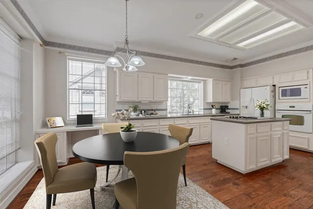 a kitchen with stainless steel appliances a dining table and chairs