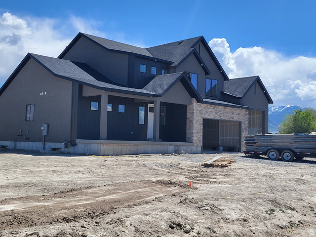 4060 North 560th West, Unit 2 Tooele, UT 84074 - Photo 1 of 1 View of front of house featuring stone siding, roof with shingles, a porch, and stucco siding