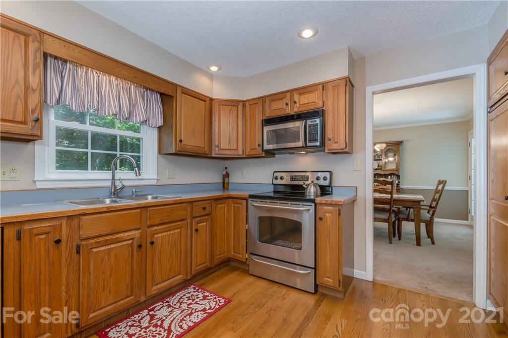 163 Fairforest Drive Rutherfordton, NC 28139 - Photo 12 of 48 a kitchen with stainless steel appliances granite countertop a stove top oven a sink dishwasher a dining table and chairs with wooden floor