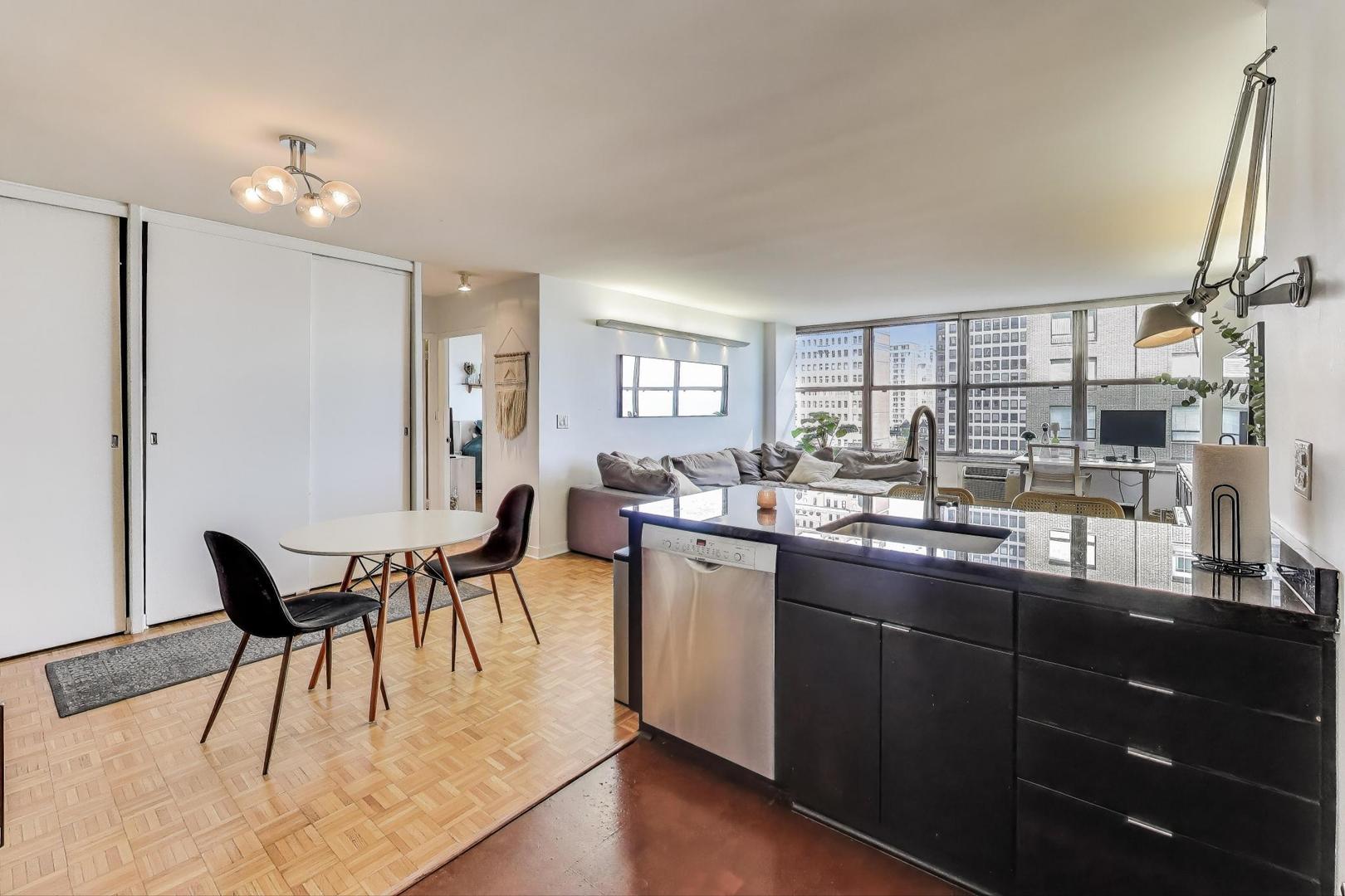 1000 North Lake Shore Plaza, Unit 804 Chicago, IL 60611 - Photo 11 of 25 a dining room with stainless steel appliances kitchen island granite countertop a table chairs and a wooden floor