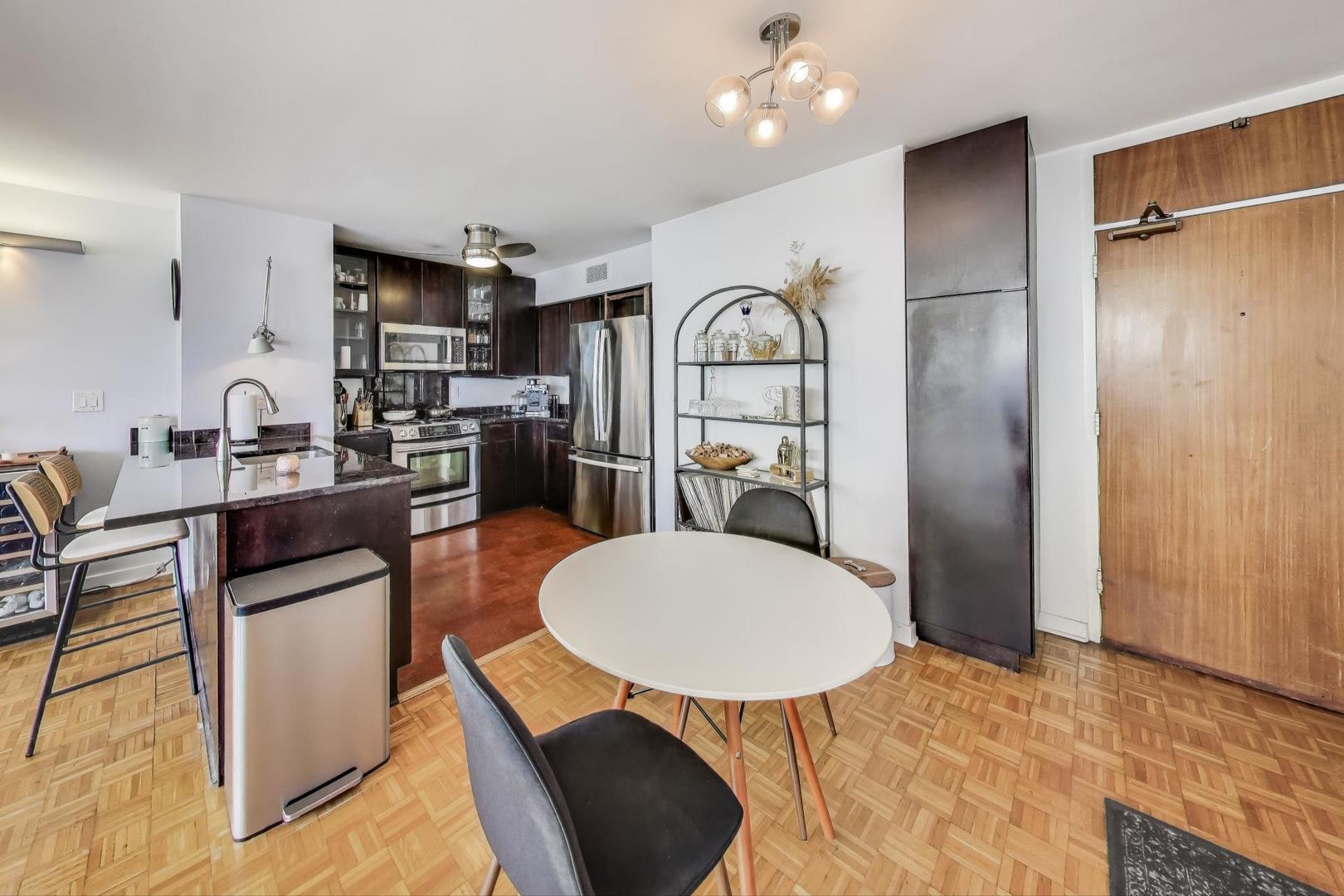 1000 North Lake Shore Plaza, Unit 804 Chicago, IL 60611 - Photo 12 of 25 a kitchen with stainless steel appliances a dining table and chairs