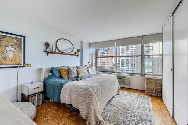 a bedroom with a bed and a large window