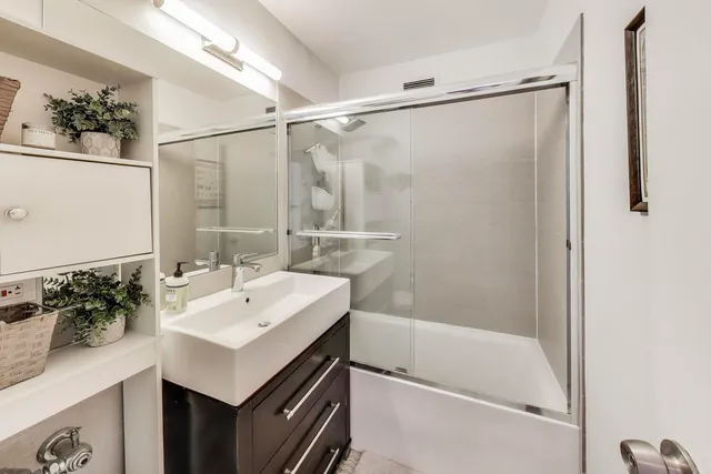 a bathroom with a sink mirror and a shower