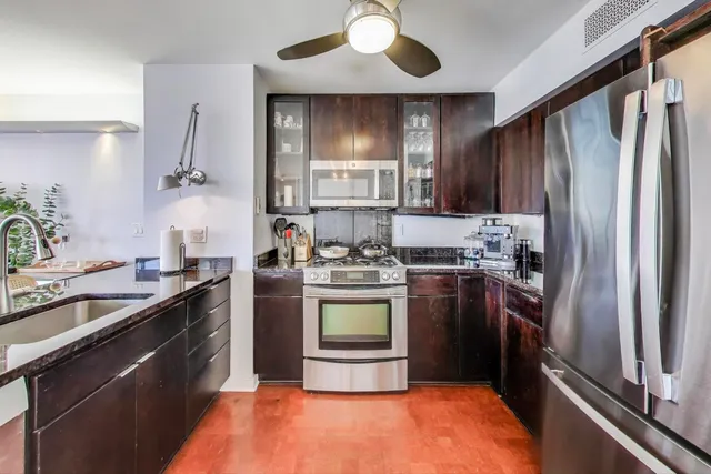 a kitchen with stainless steel appliances granite countertop a sink stove and refrigerator