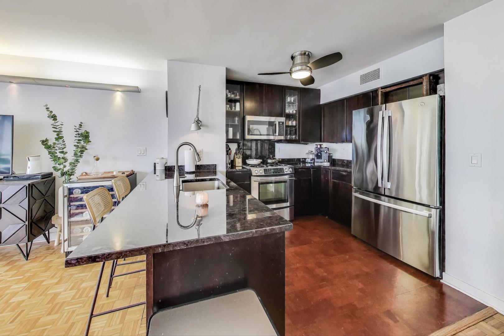 1000 North Lake Shore Plaza, Unit 804 Chicago, IL 60611 - Photo 10 of 25 a kitchen with kitchen island a counter top space cabinets and stainless steel appliances