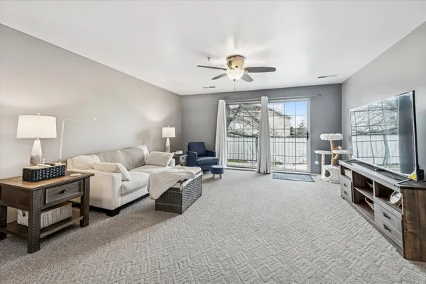 a living room with furniture a flat screen tv and a large window