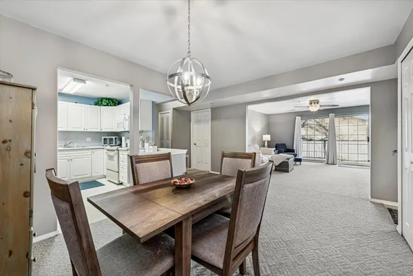 a dining room with furniture a chandelier and wooden floor