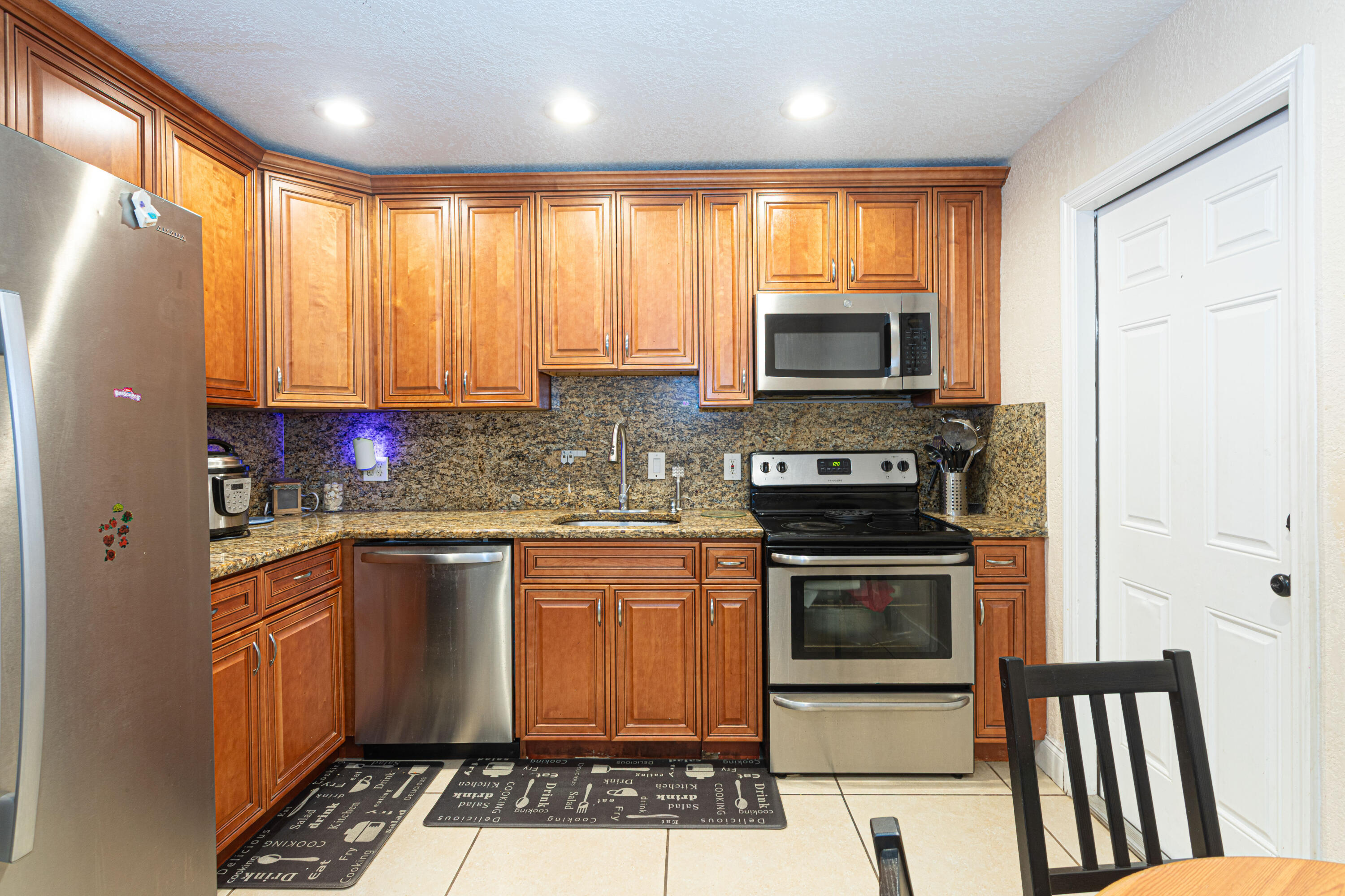 740 Aspen Road West Palm Beach, FL 33409 - Photo 14 of 34 a kitchen with granite countertop a stove a sink and a microwave